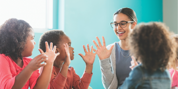 Teacher and students with hands up