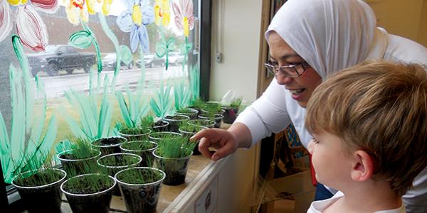 Teacher and child looking at indoor plants