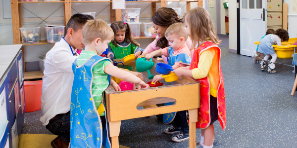 a group of children playing with a water table