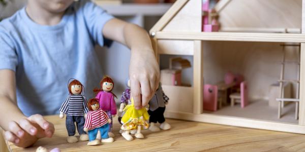 a child playing with dolls  in a doll house