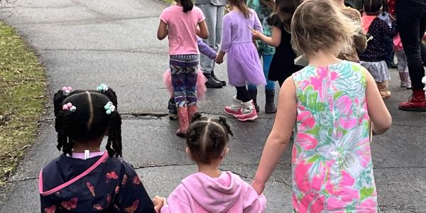 Children holding hands while walking outside