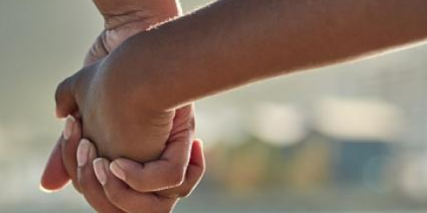 an adult holding hands with a child