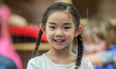 Girl smiling in middle of class