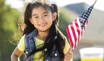 Preschool aged girl holding an american flag