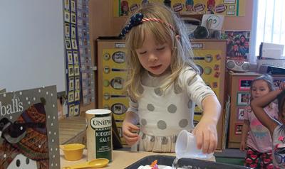 Young child doing a science experiment at table