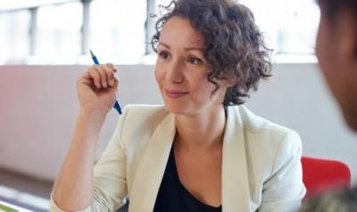 Woman in suit jacket holding a pen 