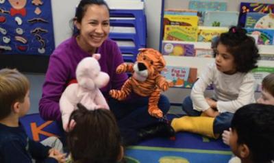 Teacher plays with puppets during group time with toddlers