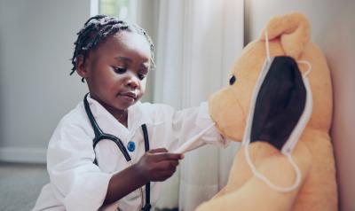 a child playing doctor with a teddy bear