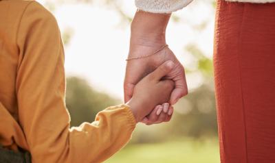 child and adult holding hands