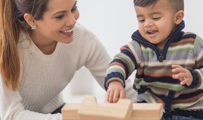 Mom and toddler son building with blocks