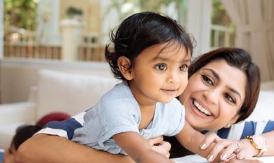 Mother holding and laughing with baby girl