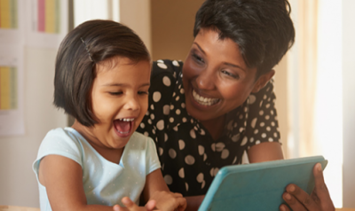 Teacher and preschooler looking at a tablet