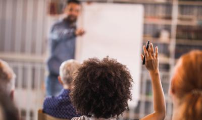 Woman raising her hand in a learning atmosphere. 