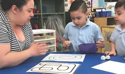 Teacher and students playing game with materials