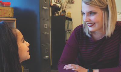 Teacher and student reading a book