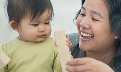 Mother playing with blocks with her young child.