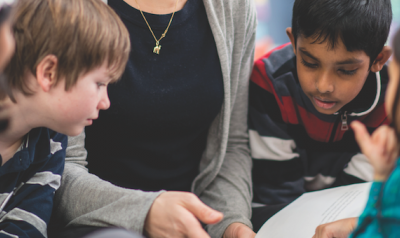 Teacher and students discussing a book