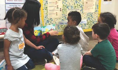 Teacher reading book to diverse students