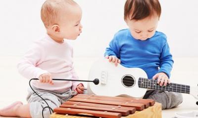 Two young children explore and play with musical instruments
