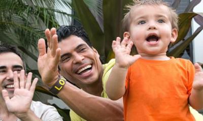 Two fathers playing with son outside