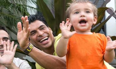 two parents with a young child clapping their hands