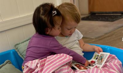 two babies looking at a book