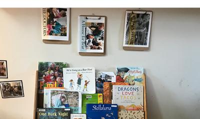 A bookshelf with children's books, some of which the children created.
