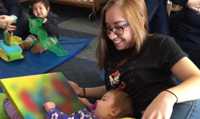 a teacher looking  at artwork with a child