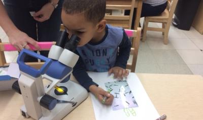 a child looking in a microscope