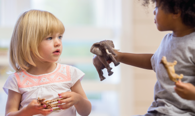 a children showing a peer an elephant doll