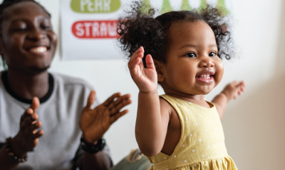 an adult and child happily clapping