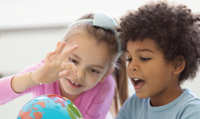 children studying a globe