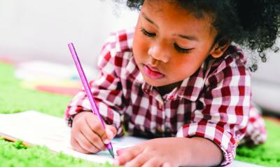A young child writing in a book