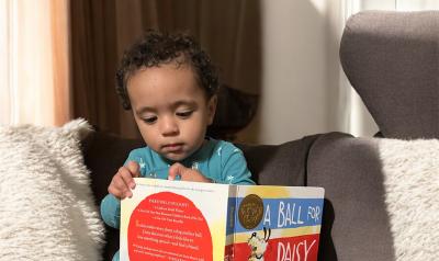 A young child reading a book at home