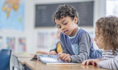 A student reading a book at his desk