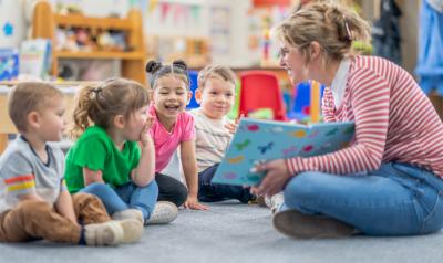 An early childhood educator reading to young children