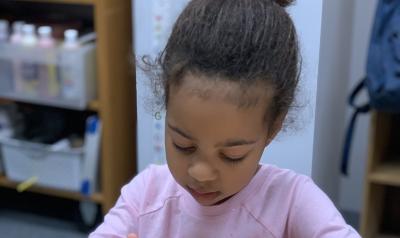 Photo of a young child working on a project in a classroom