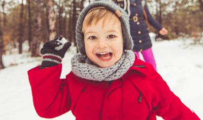 Young boy throwing a snow ball outside