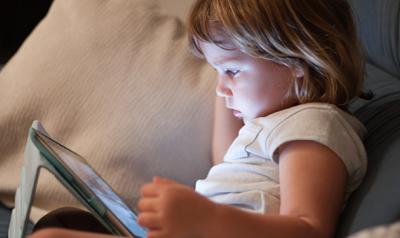Preschool girl watching a digital tablet