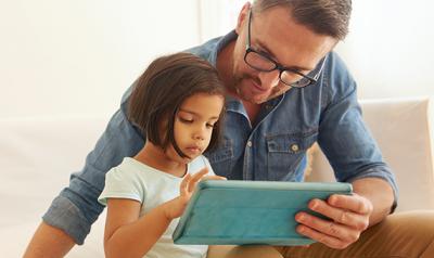 Father and daughter holding a digital tablet