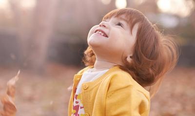 Toddler outside looking up at sky