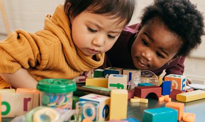 Two toddler girls playing with blocks