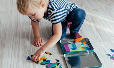 Young boy playing with shapes on the ground