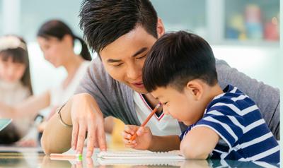 Preschooler and father writing at desk