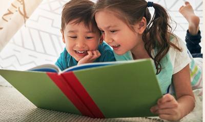 Young boy and girl read a book together