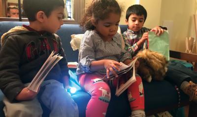 Three children reading a book