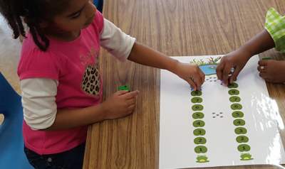 Two girls playing with lily pad math game 