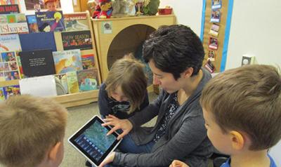 Teacher showing young children iPad