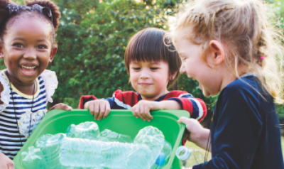 Three children with recycling bin