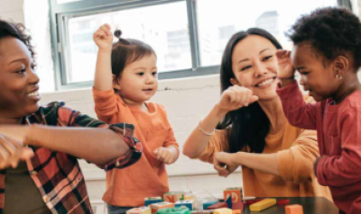 Two adults at a table playing with two toddlers.